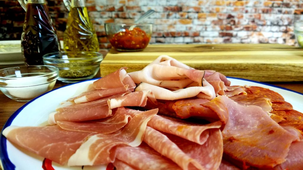 Sliced Italian cold cut meats for a Jersey Mike's Italian sub.  Ham, salami, capocollo, pepperoni, prosciutto