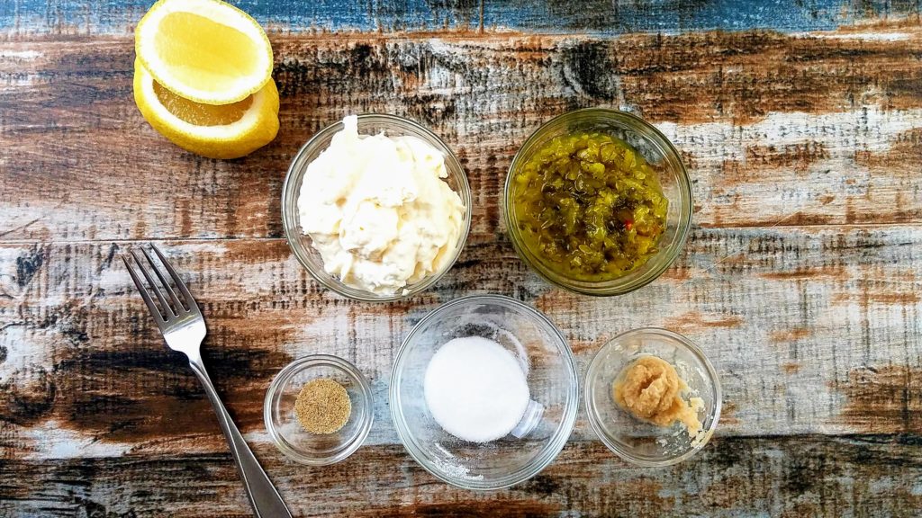 Tartar sauce recipe ingredients in bowls with lemon