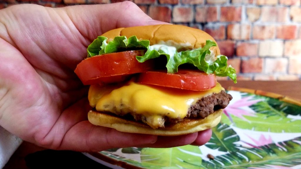 A finished Shack Burger copycat with leaf lettuce and tomato