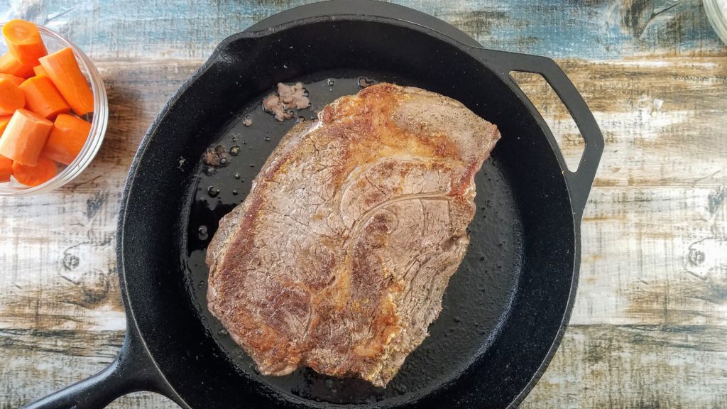 cast iron pan with seared chuck roast