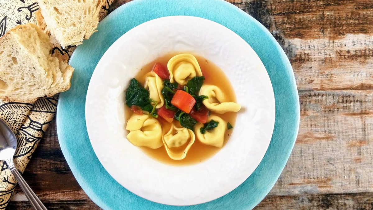 tortellini en brodo with spinach and tomatoes