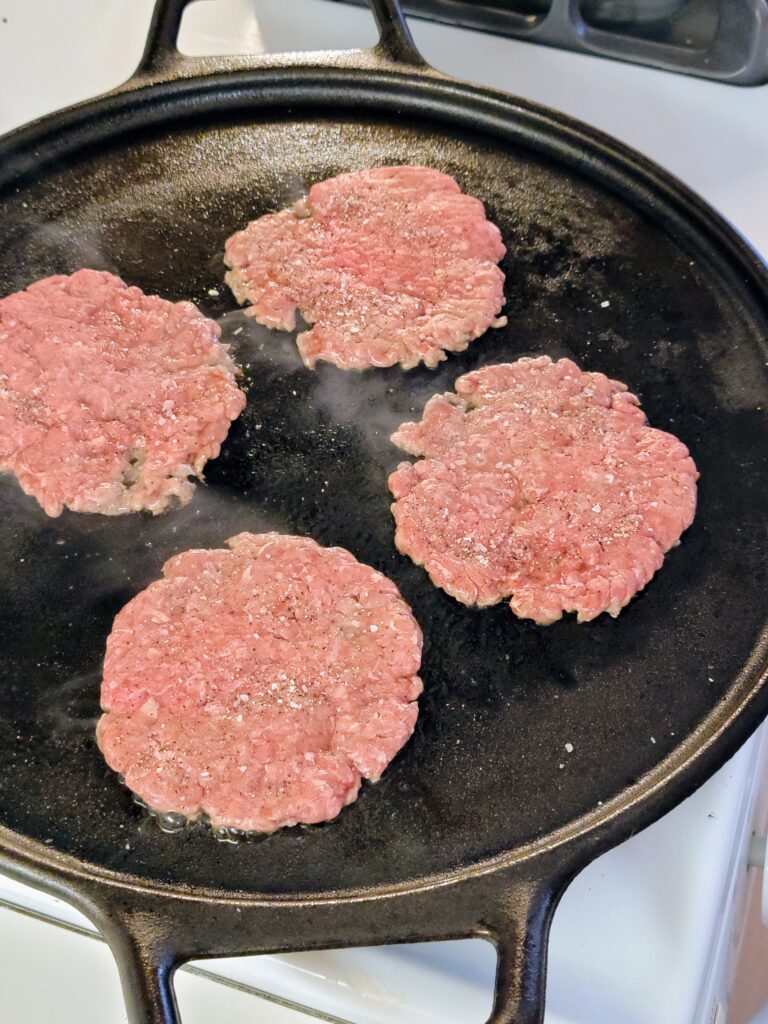 fast food burger patties on a griddle